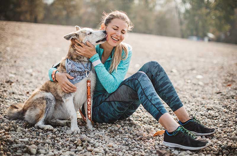 A woman on a beach with her dog